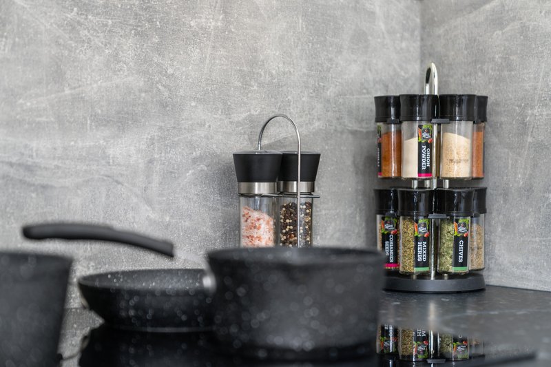 Kitchen counter with black cookware, spice jars, and rotating spice rack organizer