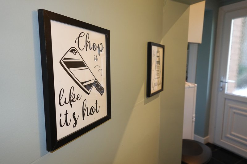 Hallway with yellow walls, framed decorative print and window with blue frame