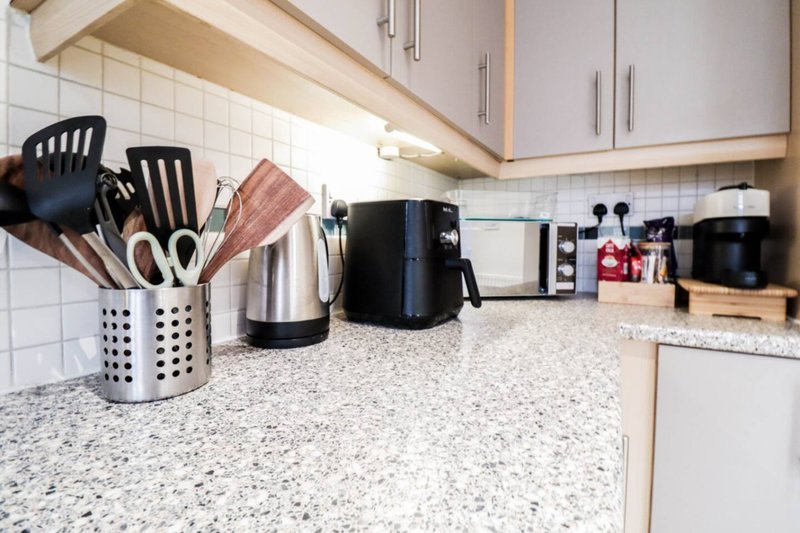 Kitchen counter with utensil holders, kettle, coffee maker and appliances