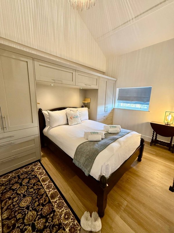 Bedroom with double bed, built-in wardrobe, wooden floor and window with sea view