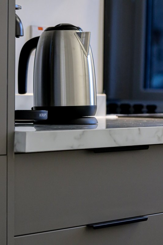 Modern kitchen counter with stainless steel electric kettle and appliances