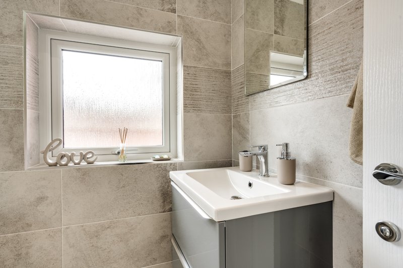 Modern bathroom with vanity sink, tiled walls, mirror and frosted window