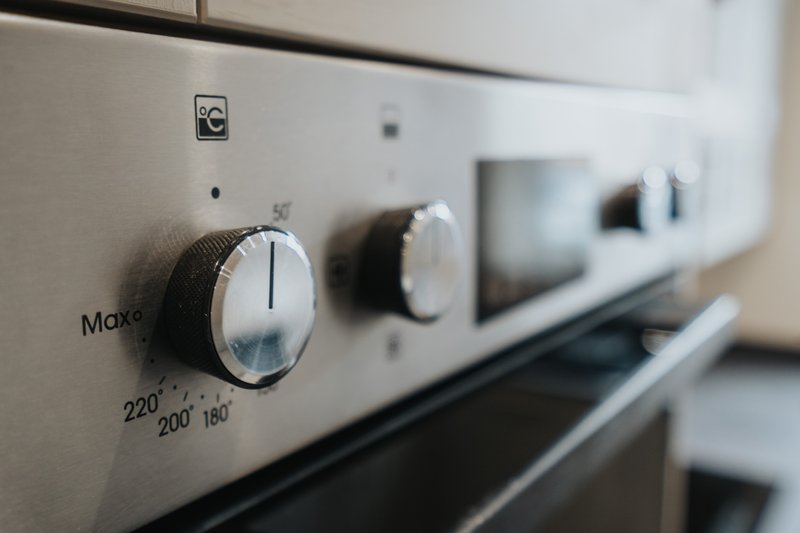 Close-up of kitchen oven controls with temperature dial and brand name visible