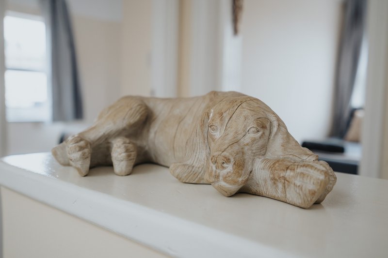 Wooden elephant sculpture displayed on white shelf in bright bedroom