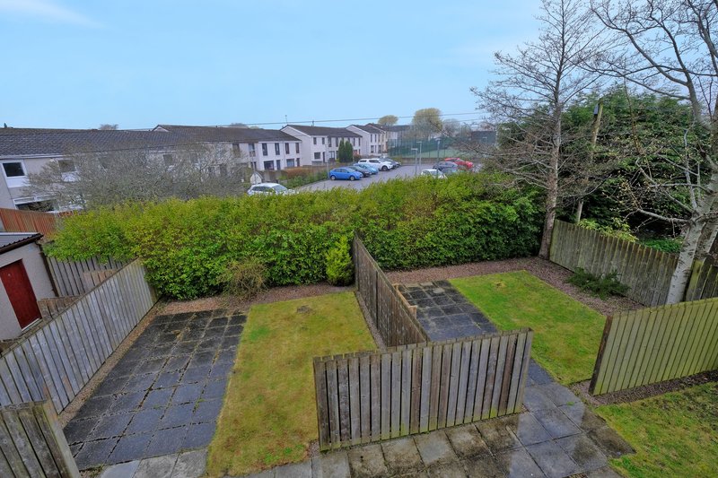 Garden view with patio, lawn, fencing and residential street beyond