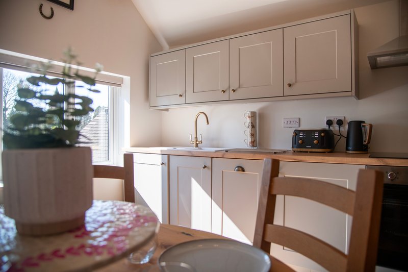 Bright, well-equipped kitchen with a modern country feel, featuring a full range of appliances, ample storage and workspace, and a lovely dining area overlooking the garden.