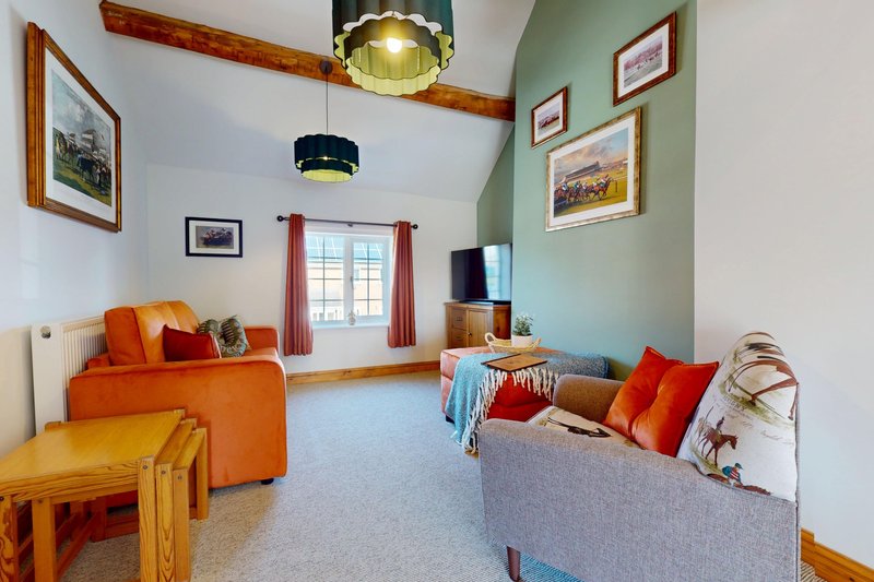 A spacious lounge with comfortable seating, a Smart TV and plenty of room for guests to relax. Exposed wooden beams, colourful furnishings and tasteful countryside décor give the room a homely feel