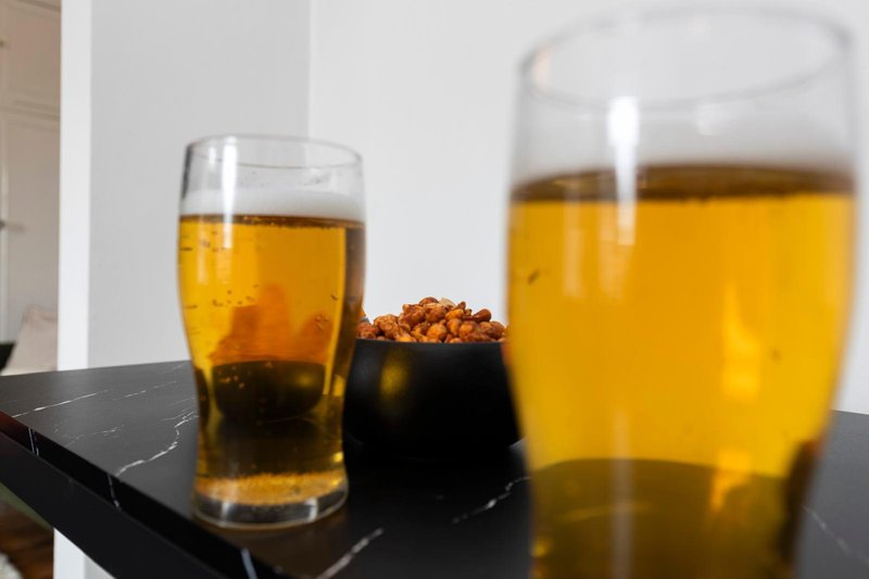 Black marble table with two glasses of cola and bowl of snacks