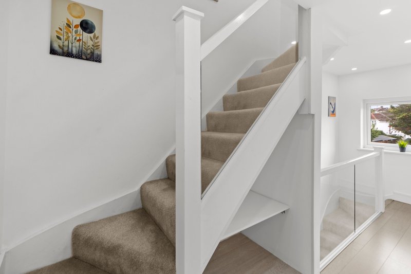 Modern staircase with grey carpet, white railings and contemporary interior design