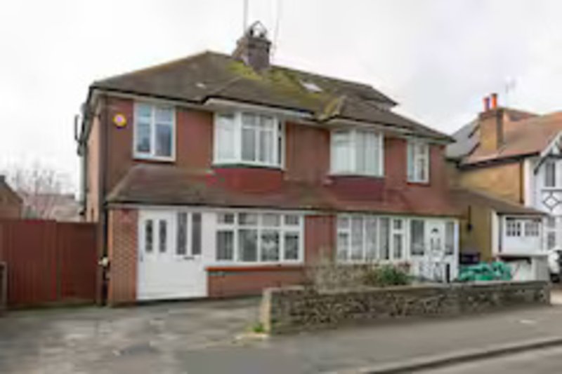 Red brick semi-detached house with driveway, garage and front garden