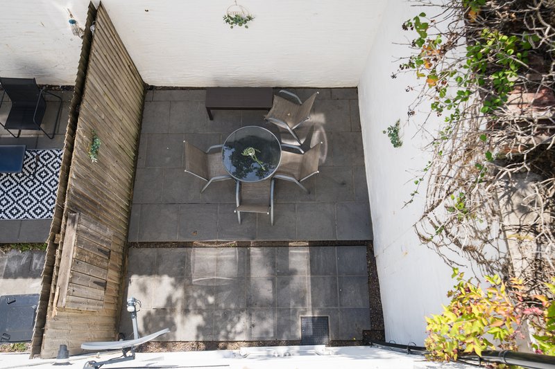Overhead view of outdoor patio with round table, chairs, and climbing ivy