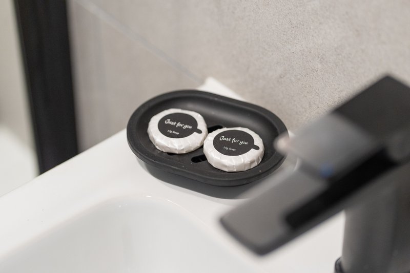 Black wireless earbuds in charging case on white surface