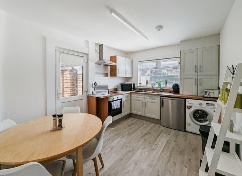 Modern kitchen with dining table, stainless steel appliances, and city view from window