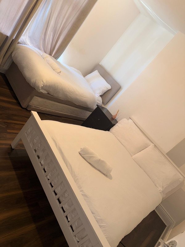 Bedroom with two beds, white bedding, wooden flooring and cream walls