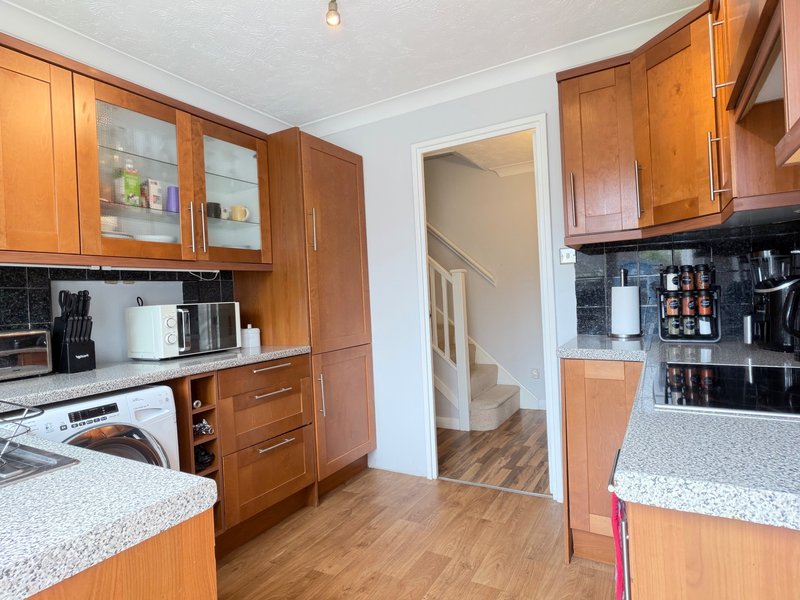 Modern kitchen with wooden cabinets, granite countertops, and appliances