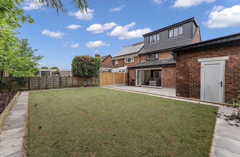 Brick house with modern extension, paved patio and landscaped garden