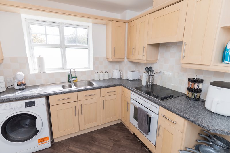 Modern kitchen with cream cabinets, granite countertops, stainless steel appliances and window