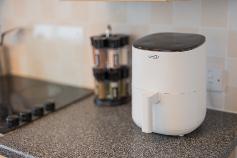 Kitchen counter with white humidifier, coffee maker, and stovetop appliances