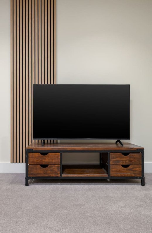 Modern living room with flat-screen TV on wooden media console and vertical wood paneling