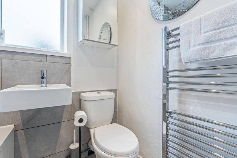 Modern bathroom with sink, toilet, heated towel rail and window