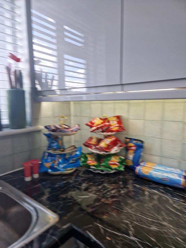 Kitchen counter with toys, colorful items, and storage containers near window