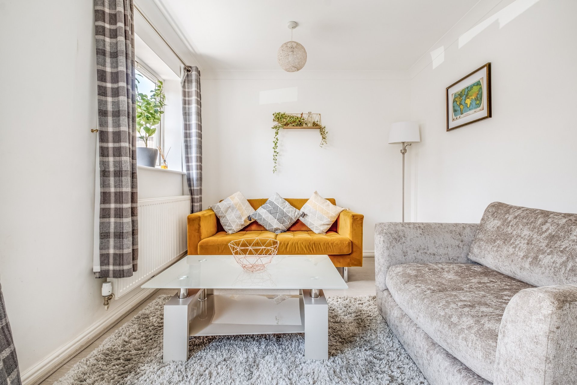 Bright living room with orange sofa, gray armchair, white coffee table and window