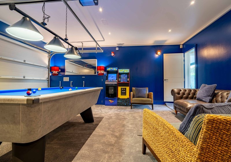Recreational room with pool table, yellow armchair, blue walls and entertainment setup
