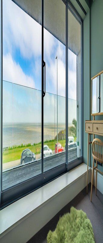 Large window with scenic rural landscape view, windowsill with decorative items and plants