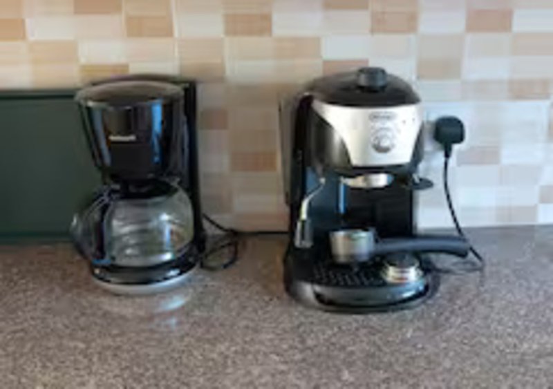 Kitchen counter with two coffee makers and checkerboard tile backsplash