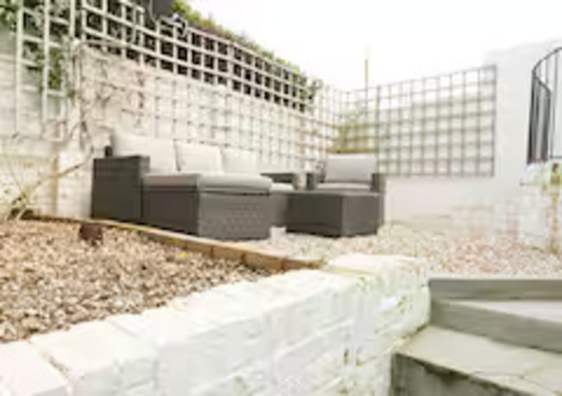 Modern patio area with outdoor seating, gravel landscaping, and lattice screening