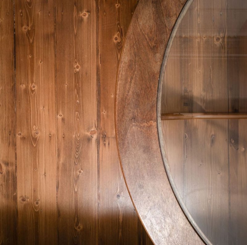 Wooden floor with curved metal structural detail, warm wood tones