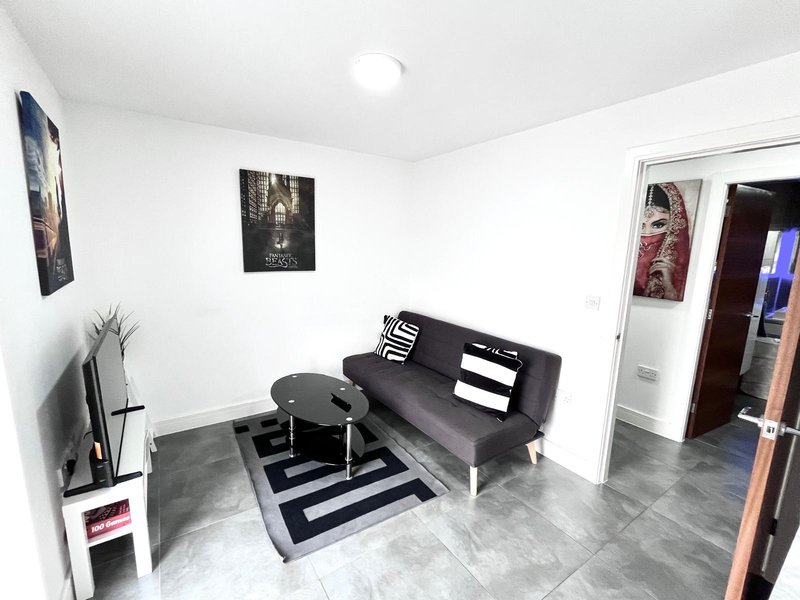 Modern living room with dark sofa, round coffee table, striped rug and wall art