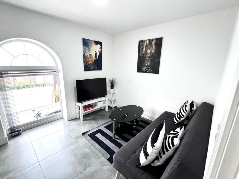 Modern living room with black sofa, TV stand, striped rug and wall art