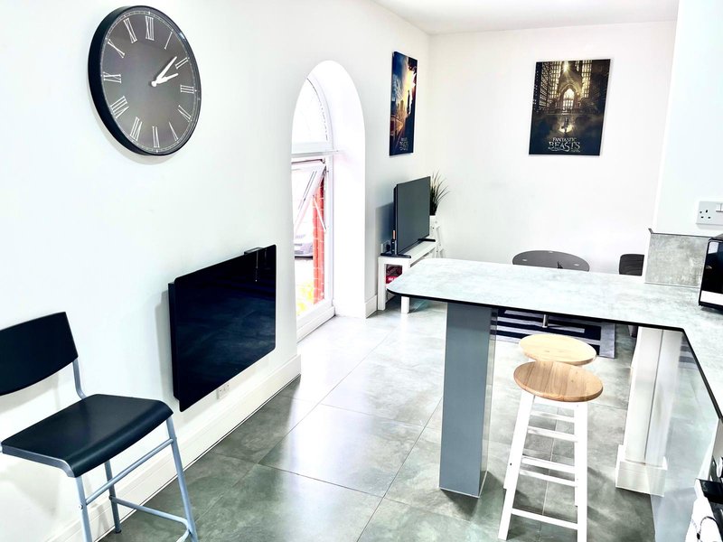 Modern office space with desk, chairs, wall clock, and framed wall art