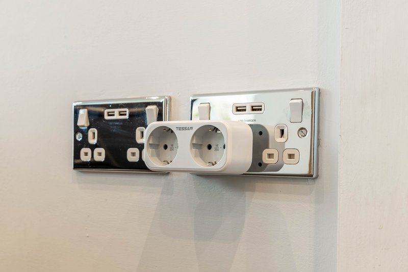 Wall-mounted electrical outlets and USB charging ports on white wall
