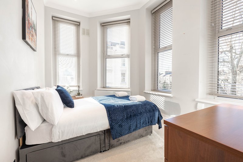 A comfortable and thoughtfully furnished bedroom with a double bed and dedicated workspace, ideal for solo travellers or children. Plenty of natural light creates a calm and inviting atmosphere.