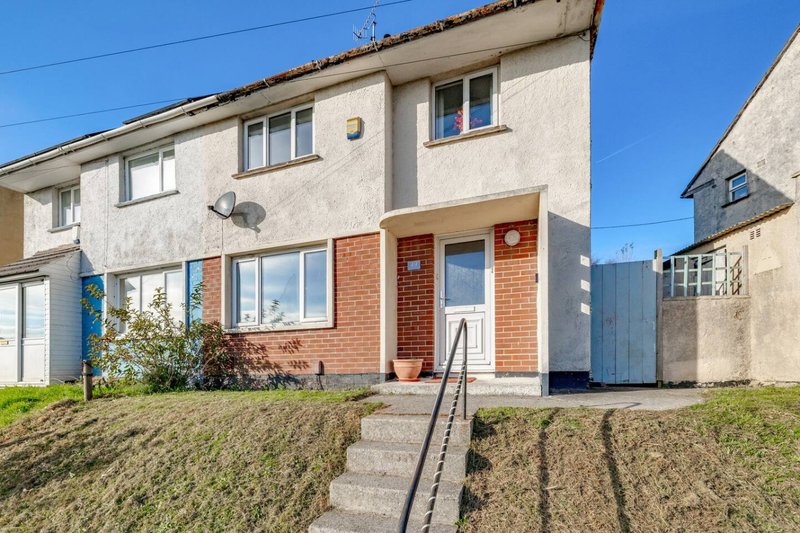 Semi-detached brick house with front entrance, steps, lawn and driveway