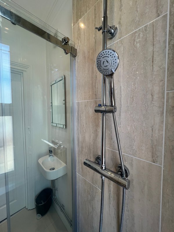 Modern bathroom with shower enclosure, wall-mounted showerhead and basin sink
