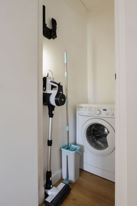 Utility closet with washing machine, cleaning supplies and storage equipment