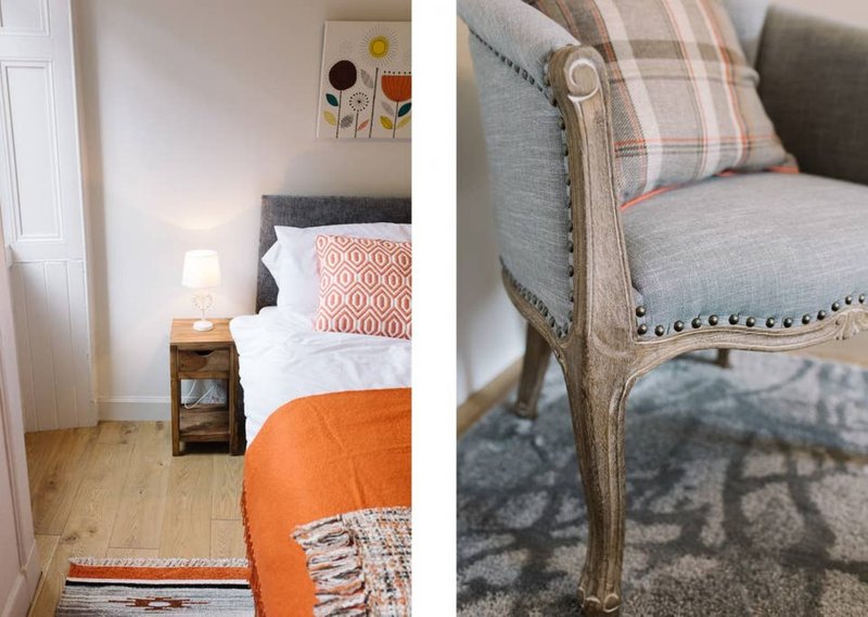 Bedroom with double bed, bedside lamp, wooden nightstand, and upholstered armchair detail