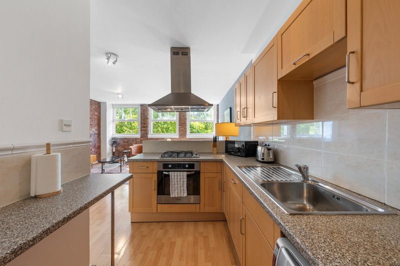 Modern kitchen with wooden cabinets, stainless steel appliances, granite countertop and island