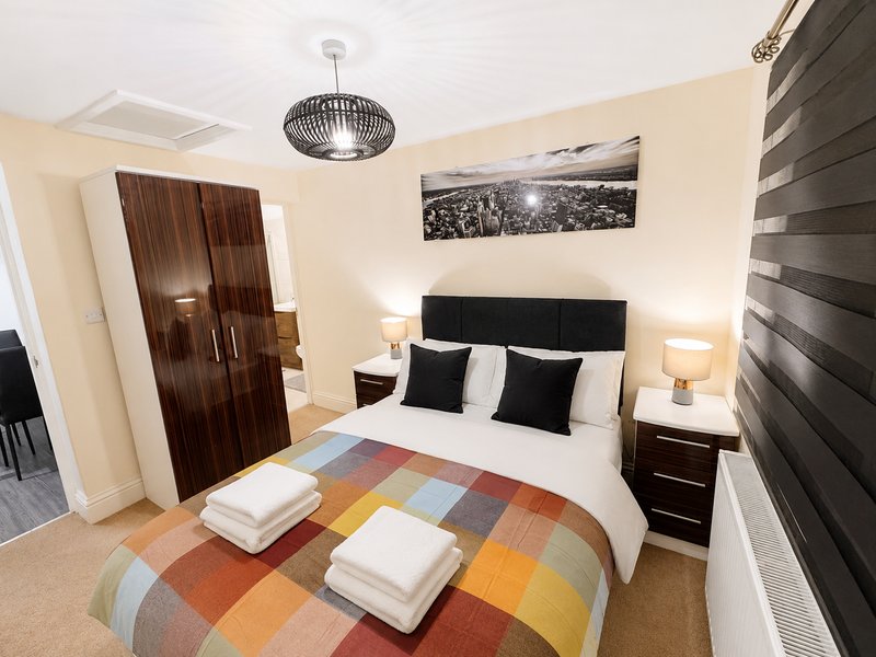 Modern bedroom with double bed, black headboard, pendant light and contemporary furnishings