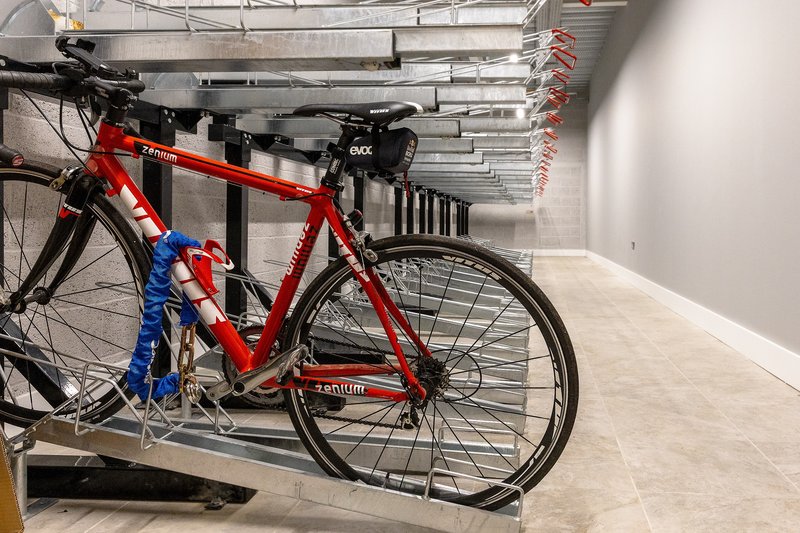 Storage area with red bicycle on rack and industrial ceiling pipes