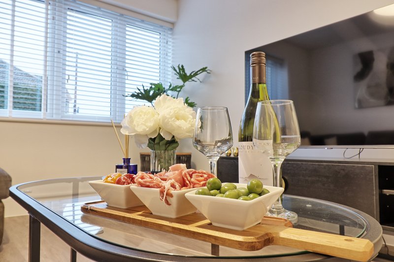 Modern dining table with flowers, wine bottle, glasses, and appetizers displayed