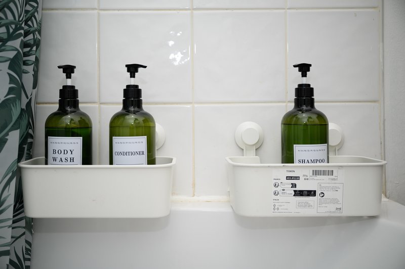 Bathroom shelf with toiletry bottles, soap dispensers, and white storage organizers