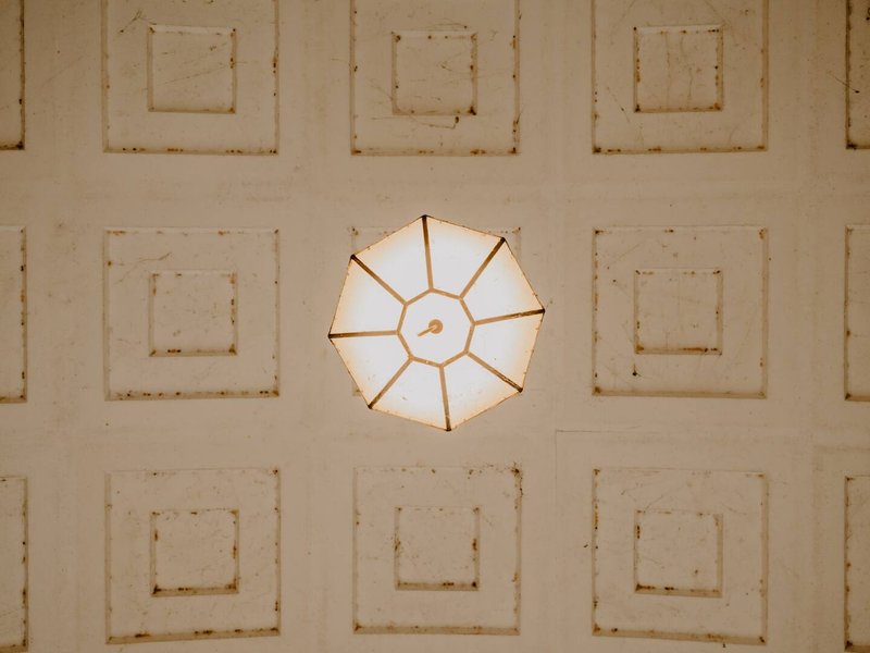 Coffered ceiling with geometric panels and central chandelier fixture