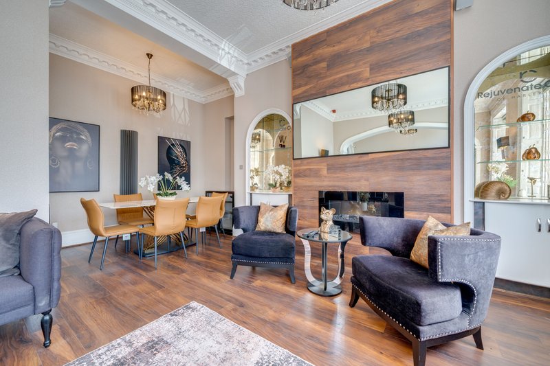 Open-plan living and dining area with wooden flooring, fireplace, and contemporary furniture