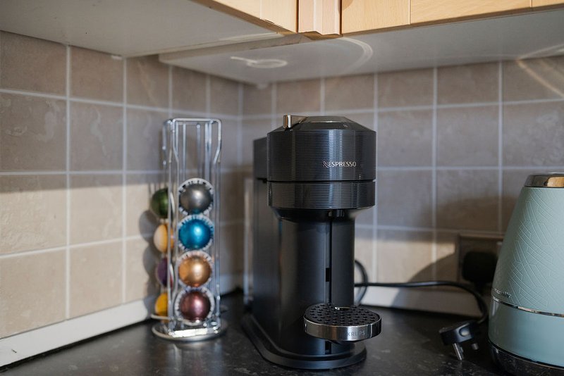 Kitchen countertop with coffee maker, capsule holder, and decorative items