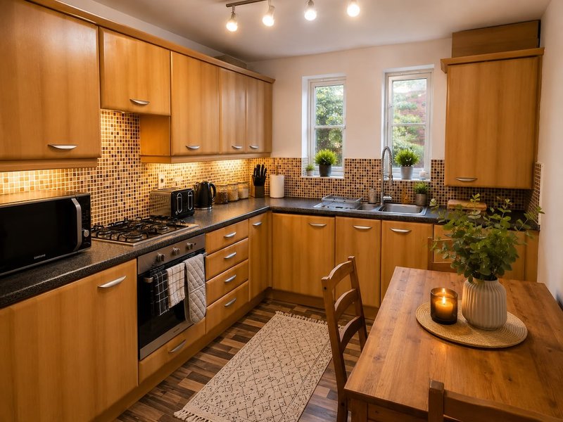Modern kitchen with wooden cabinets, black countertops, tiled backsplash and dining table