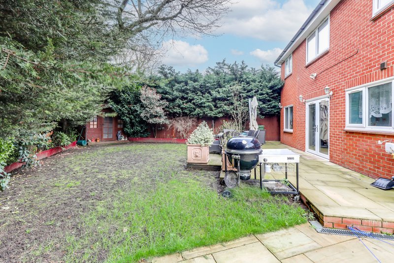 Red brick house with garden patio, lawn, BBQ grill and landscaping
